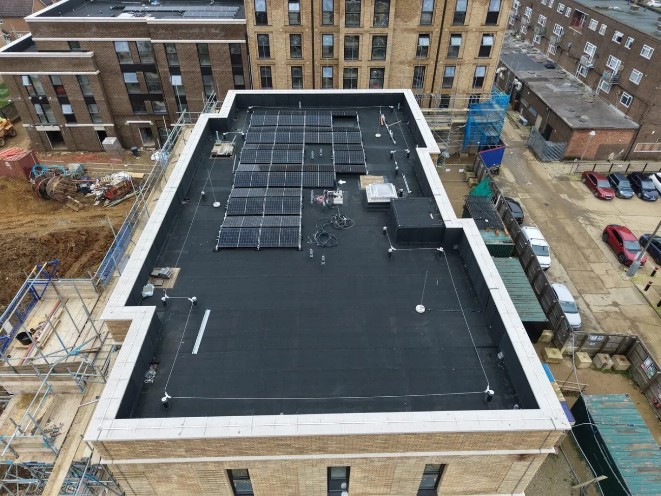 Flat roof aerial view showing the completed waterproofing system and mansafe posts.