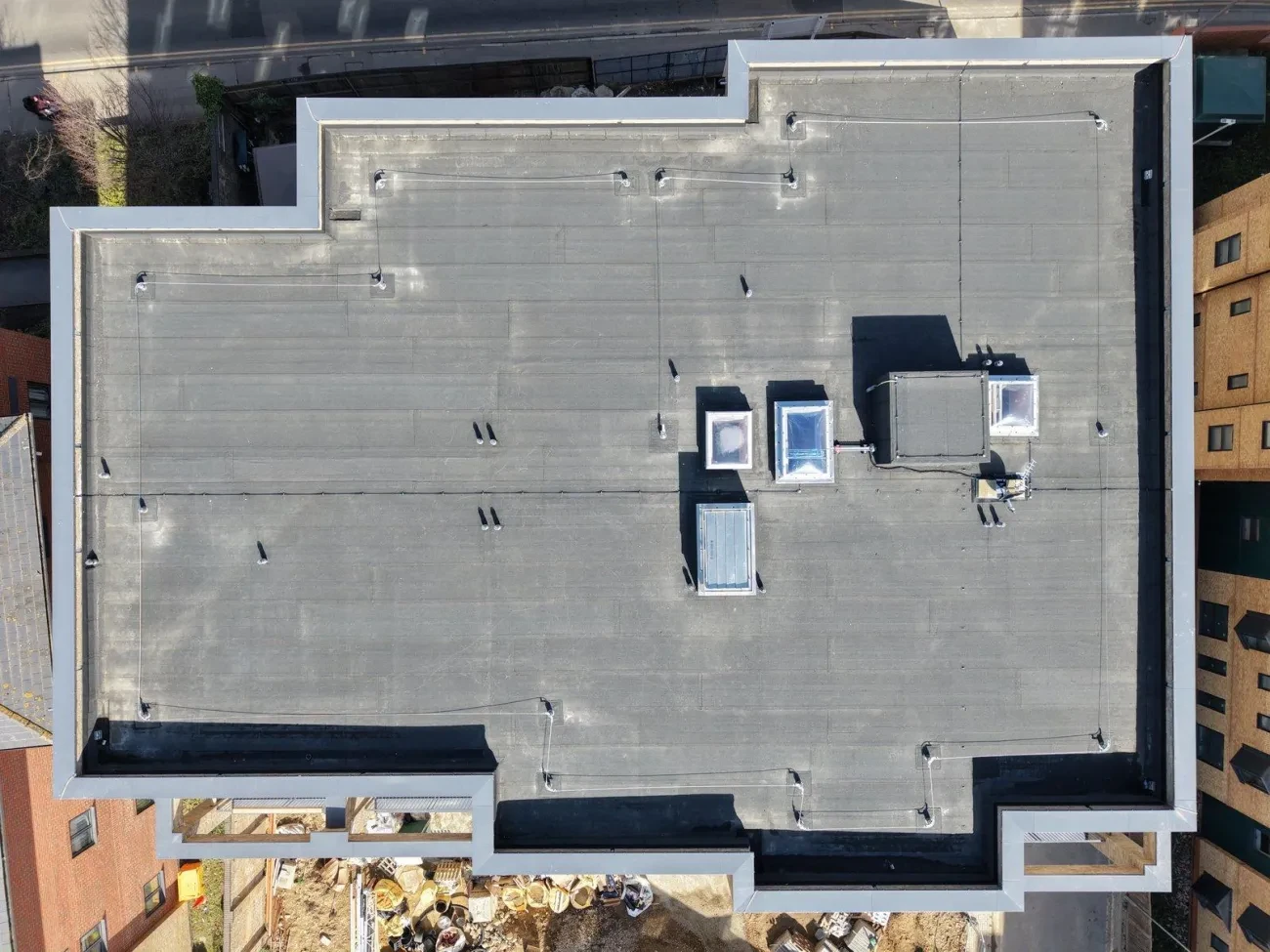 Aerial plan view – main roof showing membrane laps, HLL wire runs, vent collars and roof penetrations