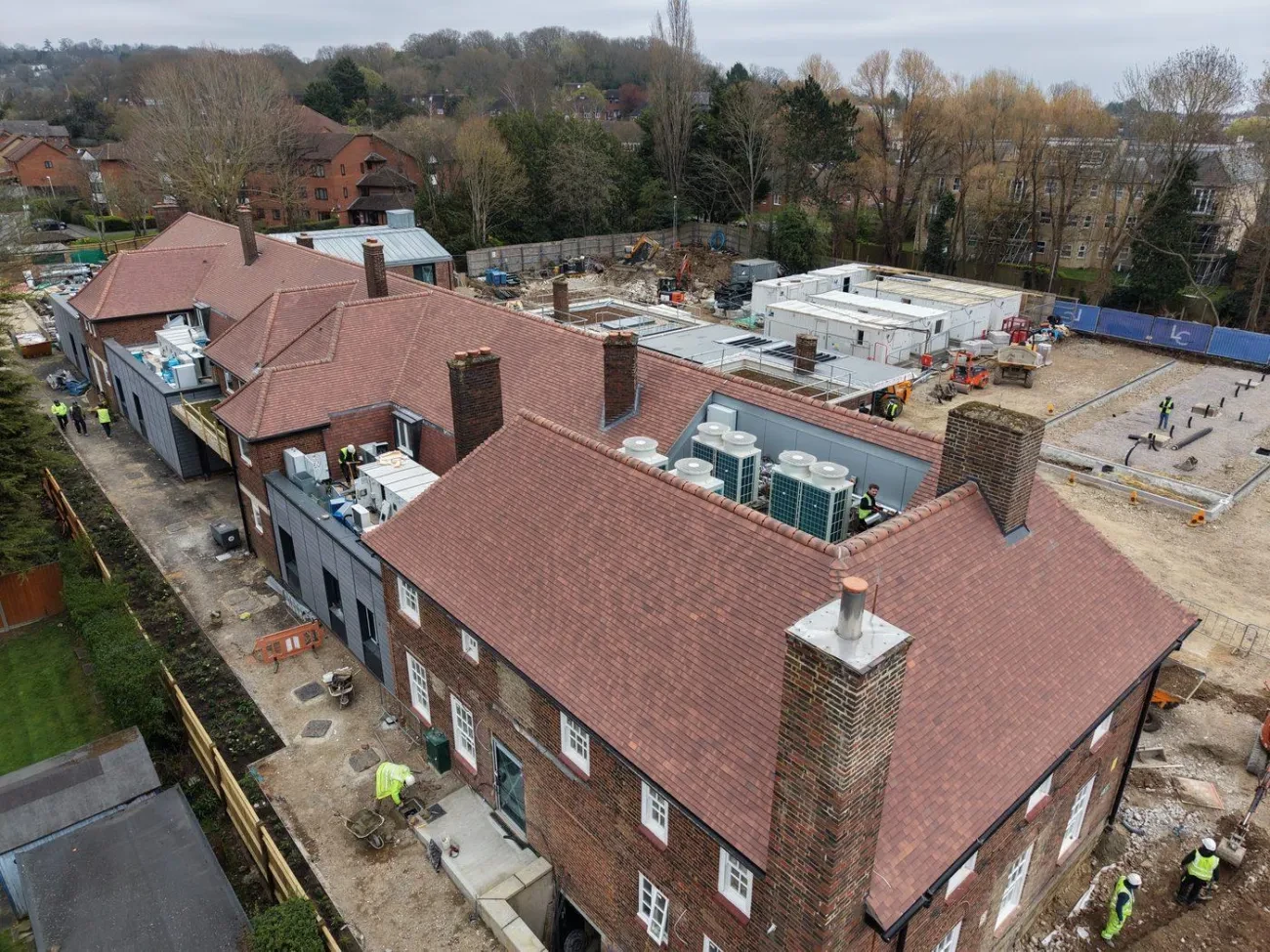 Overview of the main building and new build extension showing the re-tiled pitched roof alongside the flat roof areas beyond.