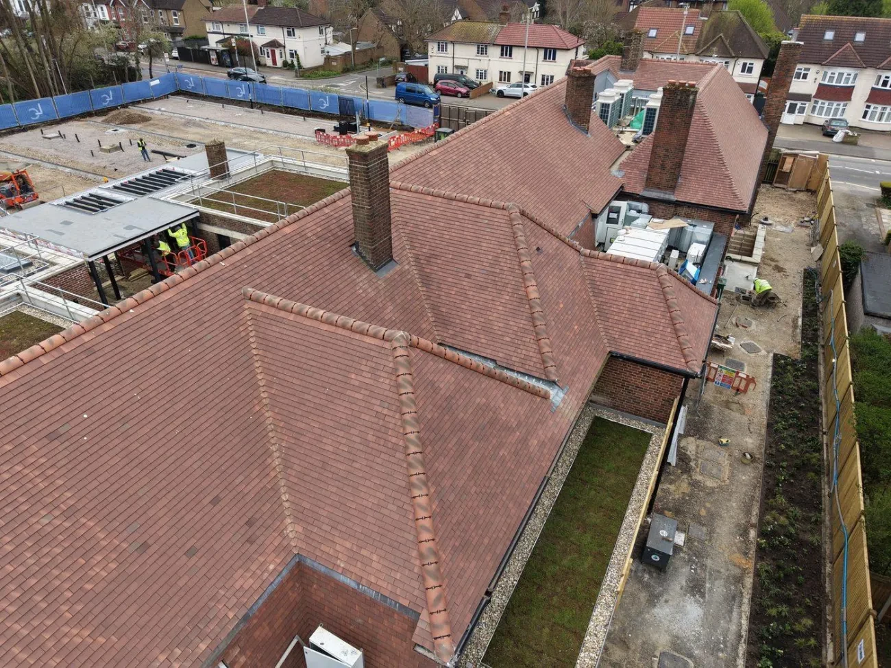 Aerial view of the complex hipped roof geometry showing ridge, hip and valley junctions with Marley Plain Tiles.